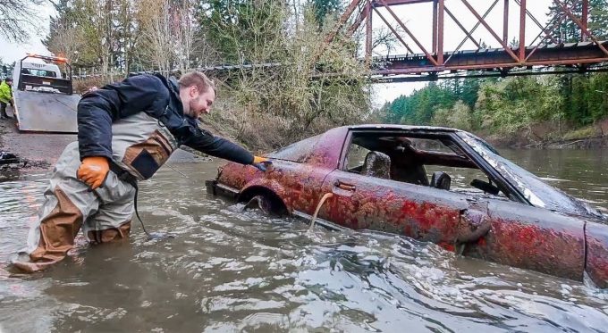 Мужчина вылавливает автомобиль в реке